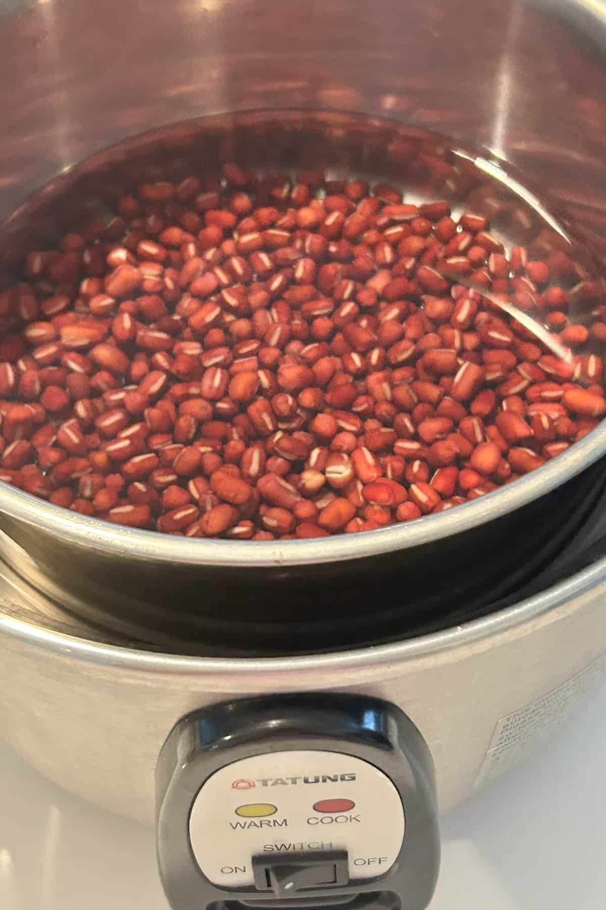 Inner pot with red beans and water in the rice cooker