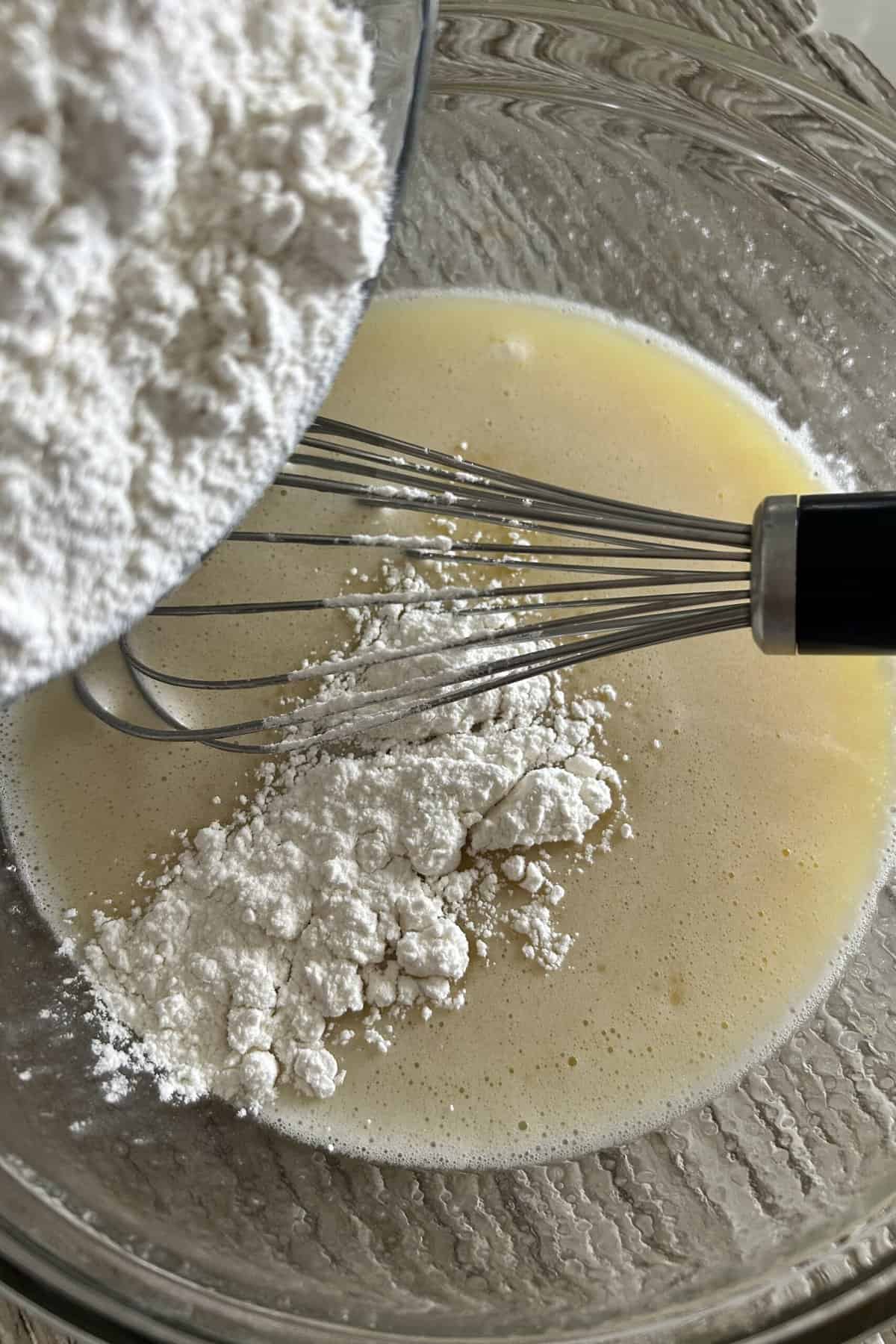 Add flour to the butter and egg mixture in the glass bowl