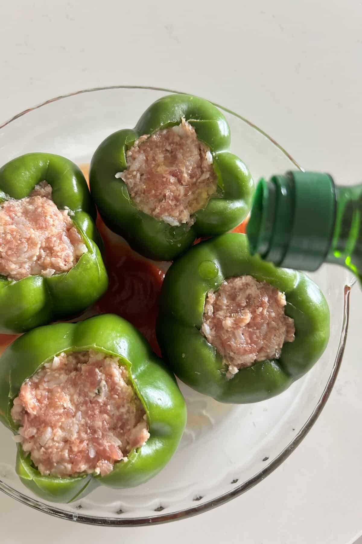 Peppers stuffed with meat mixture and dried with olive oil in a glass baking dish