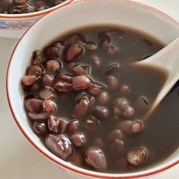 Cooked sweet red bean soup in a Chinese porcelain bowl with a Chinese porcelain spoon