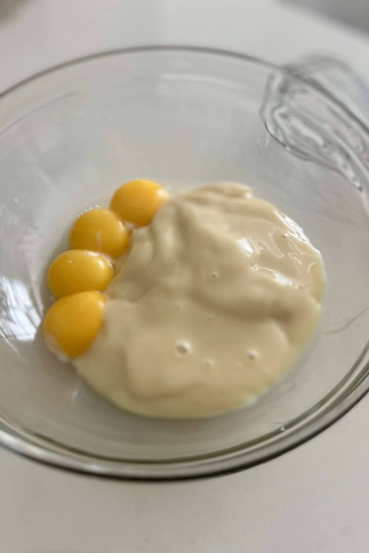 Put sweetened condensed milk and four egg yolks in a glass bowl