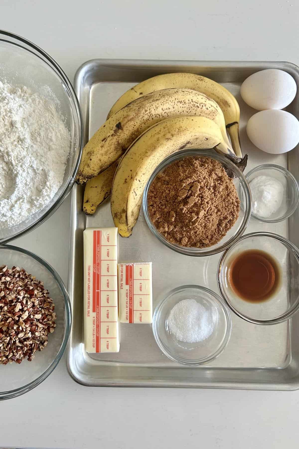 Banana nut muffin ingredients: flour, chopped nuts, bananas, eggs, brown sugar, baking soda, salt, butter and vanilla extract