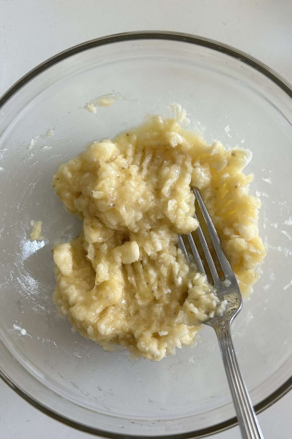 Use a fork to mash two bananas in a glass bowl