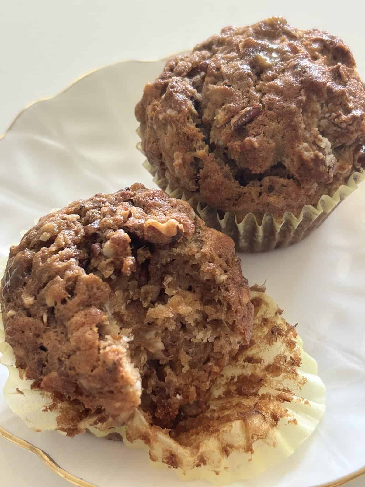 Baked banana nut muffins on a white plate with gold rim