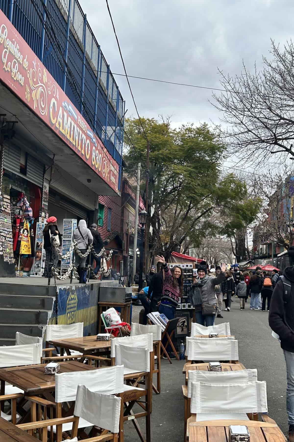 Friend and a street vendor waving at me in Caminito