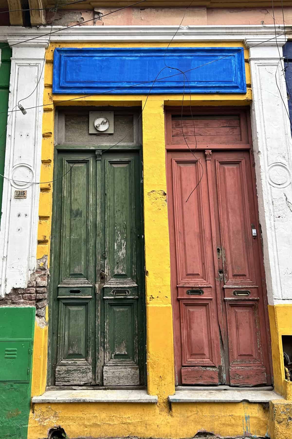 Red and green old doors with blue on top in Caminito