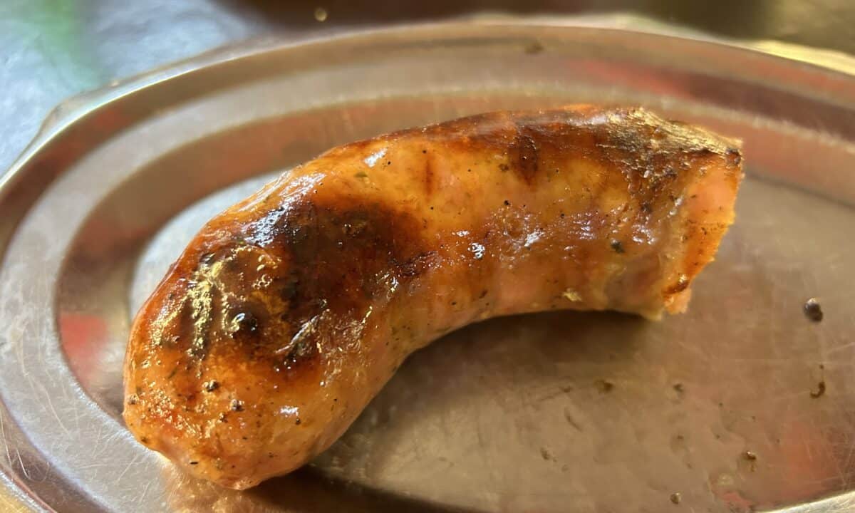 Half of a sausage on a metal plate at El Desnivel