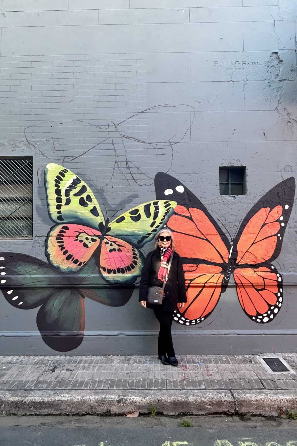 Butterfly street art on a wall in Buenos Aires with me standing there