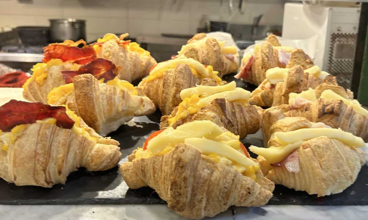 Ham and cheese croissants and bacon and egg croissants on display at a bakery in San Telmo Market