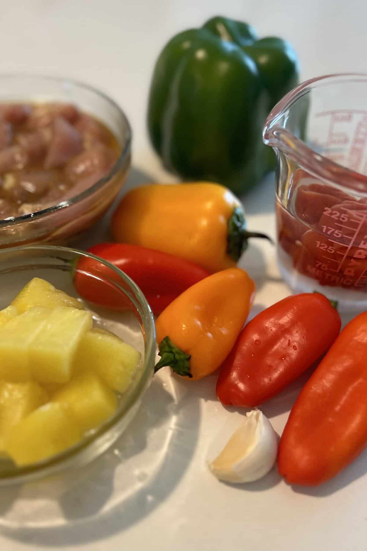 Chicken, green, orange, red, yellow peppers, pineapple, garlic and sweet and sour sauce mixture