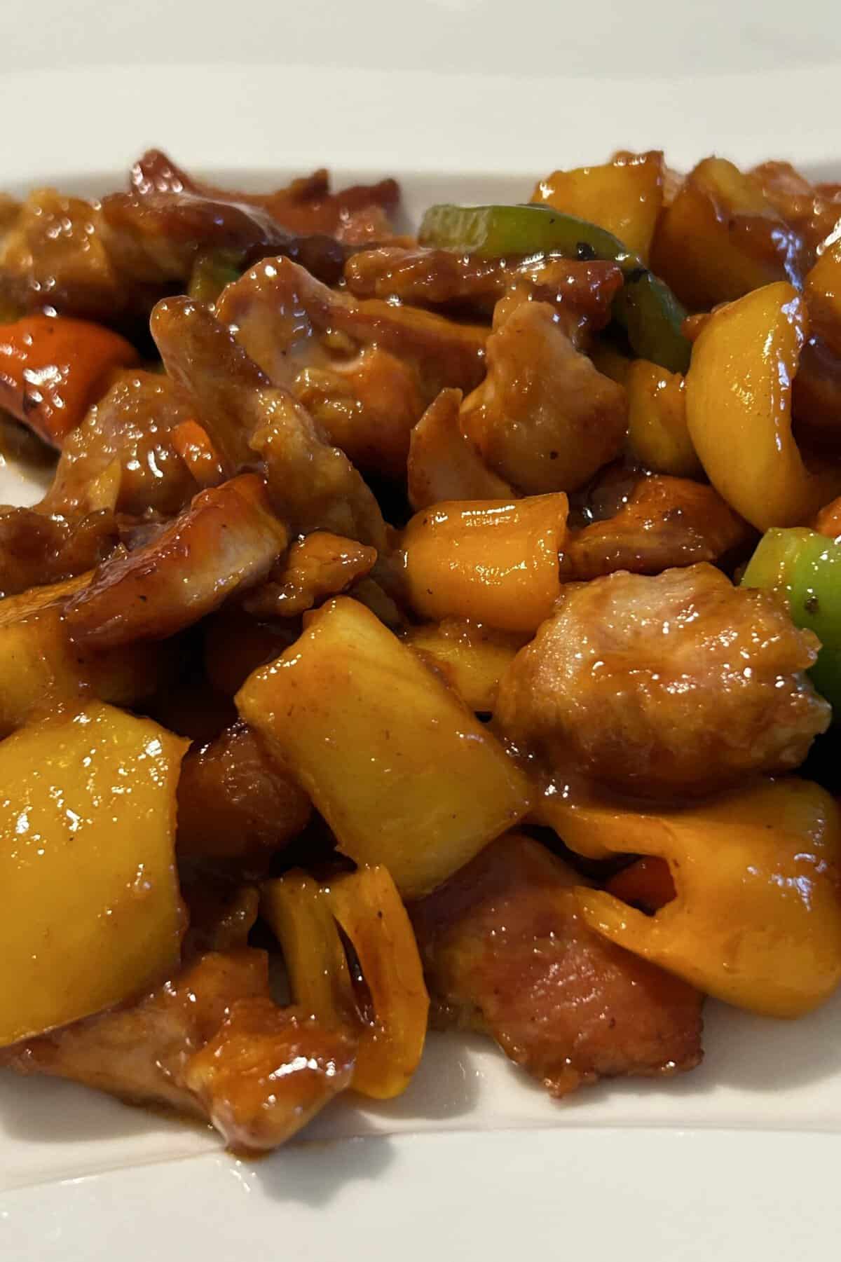 Cooked sweet and sour chicken on a white plate