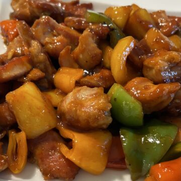 Cooked sweet and sour chicken on a white plate ready for serving