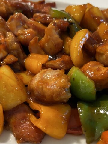 Cooked sweet and sour chicken on a white plate ready for serving