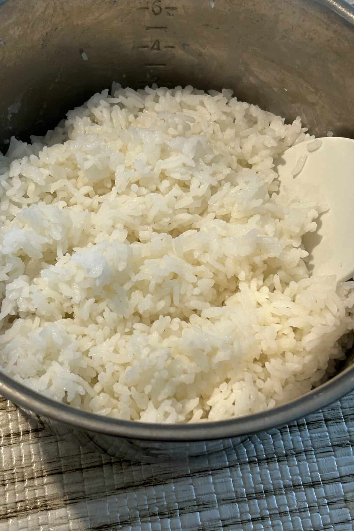 Use a spatula to fluff up the cooked rice.