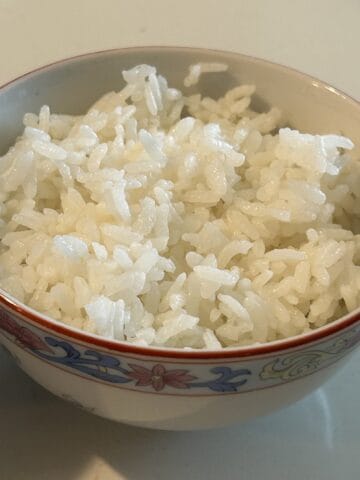 Fluffy white rice in a small Chinese rice bowl ready to serve.