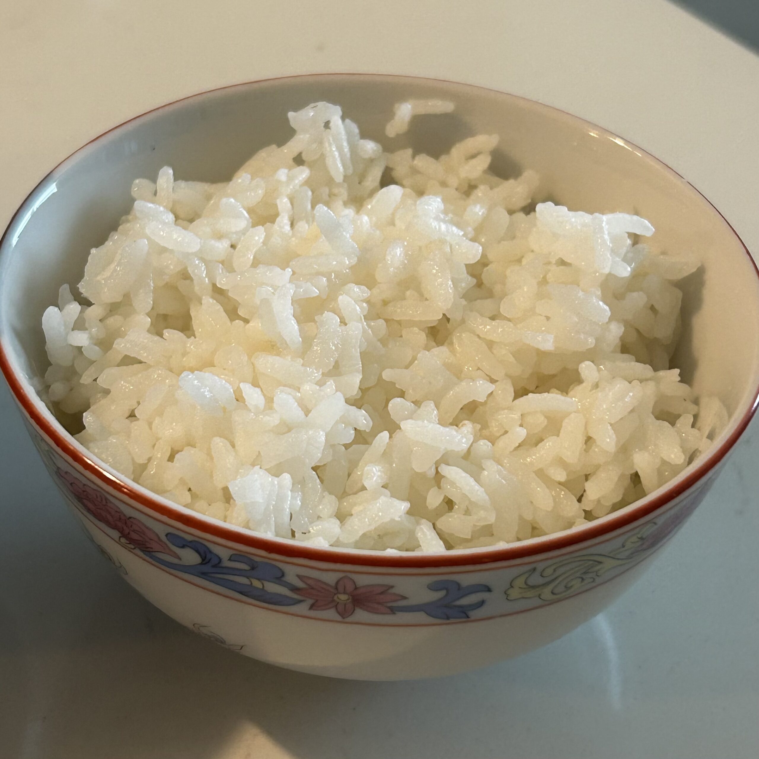 Fluffy white rice in a small Chinese rice bowl ready to serve.