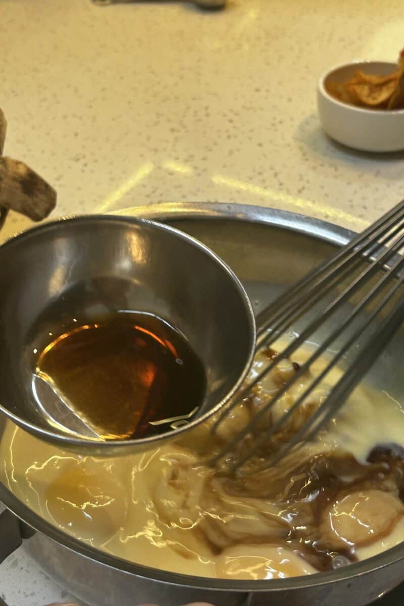 Mixing eggs milk vanilla extract in a bowl for flan