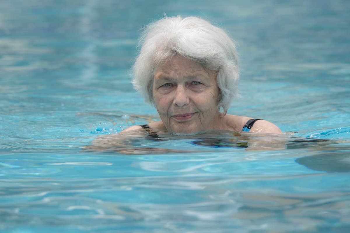 A senior lady with silver hair in the swimming pool