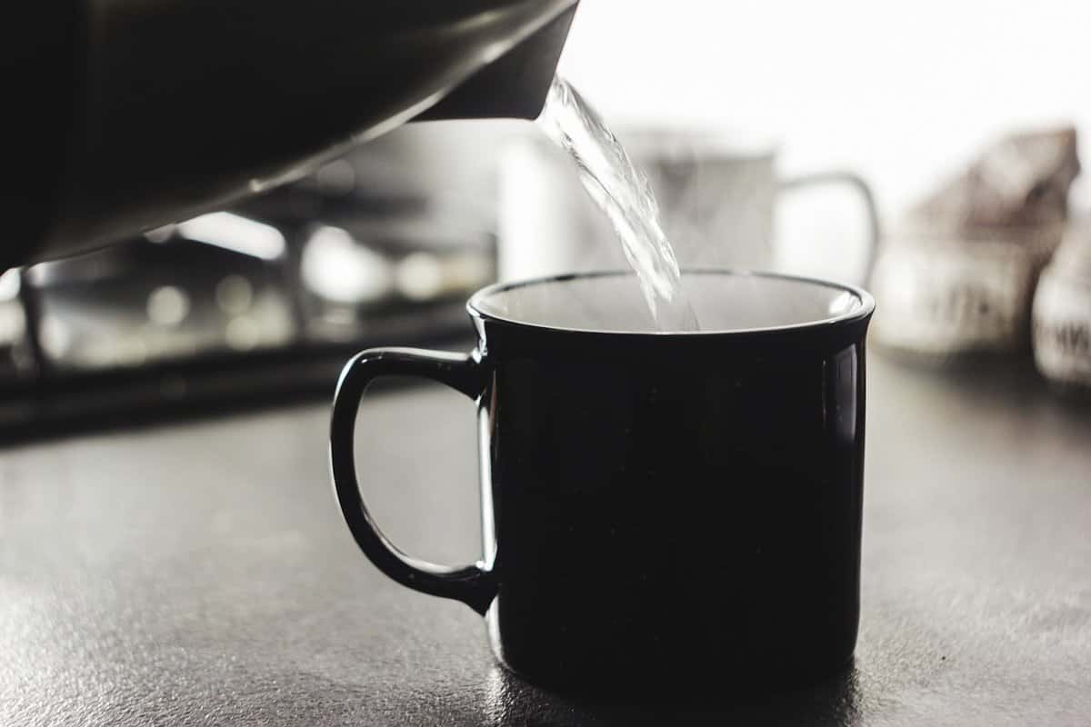 Pour hot water into a dark cup