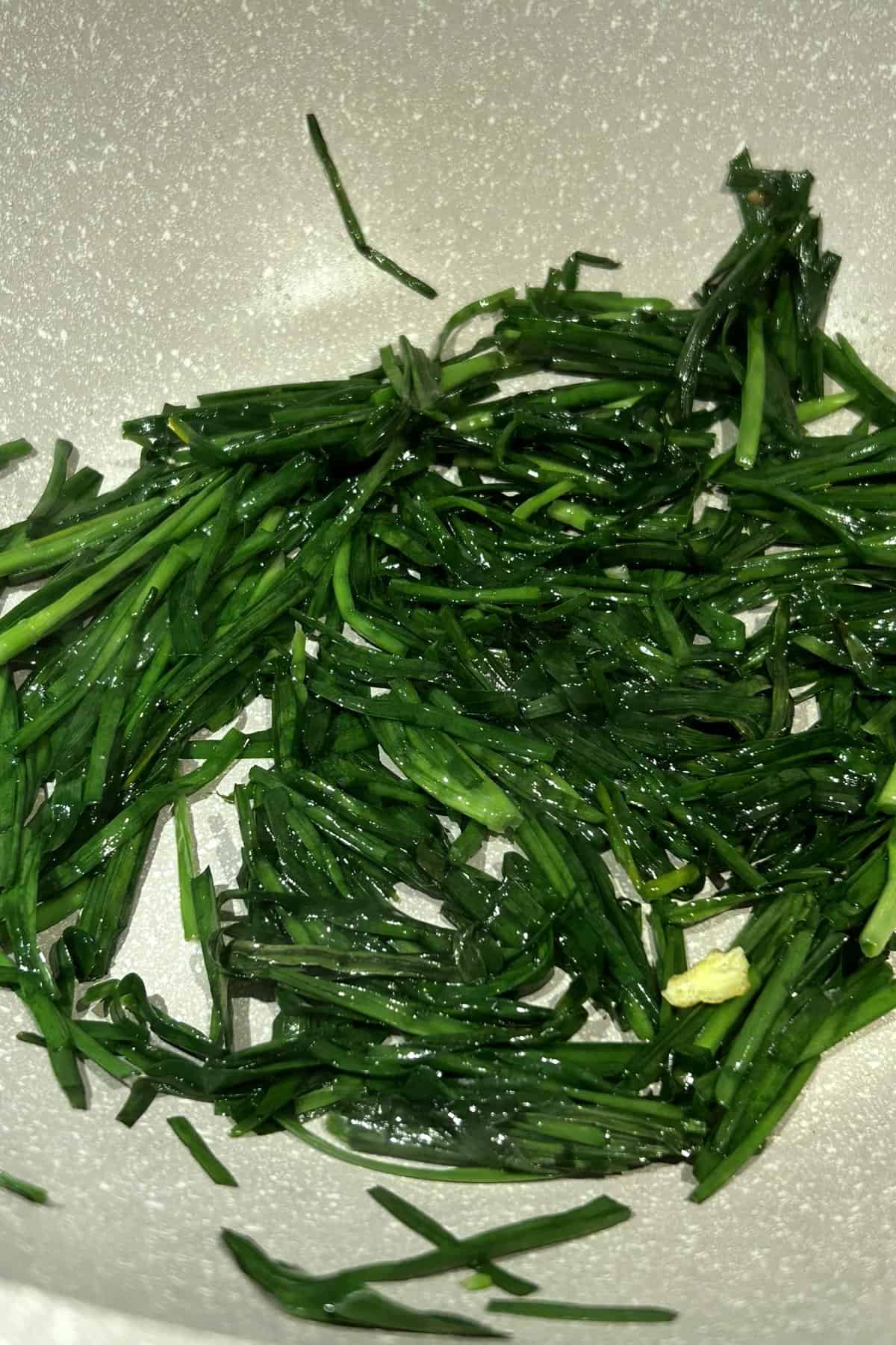 Cooking Chinese chives in a wok